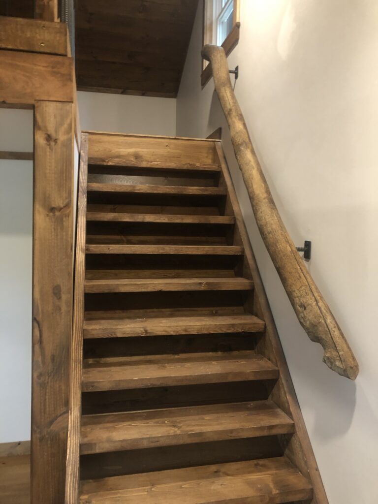 Stairs to a loft with actual beaver chewed wood as a railing 
